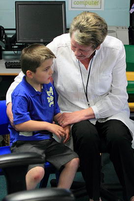 A teacher holds a boy's hand