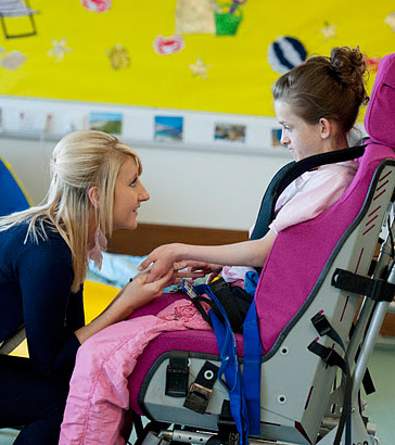 A teacher holds the hands of a
girl in a wheelchair