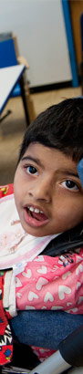 A teacher holds a boy’s feeding
                  tube