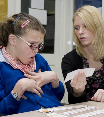 Teacher helps disabled girl to
recognise cards.