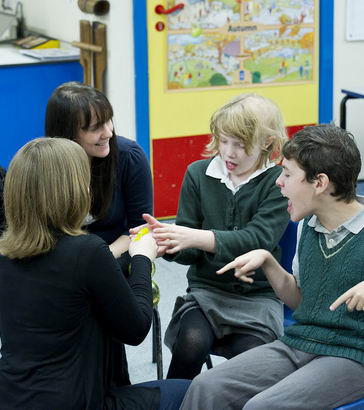 Two teachers discussing with
disabled students.