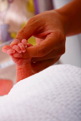 Mother holding an infant's
                  hand