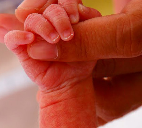 Mother holding an infent's
hand