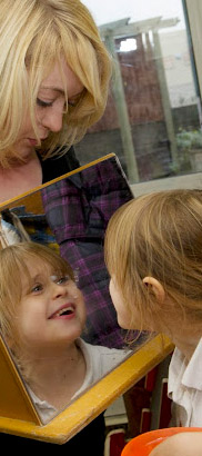 Girl looks at herself in a mirror.