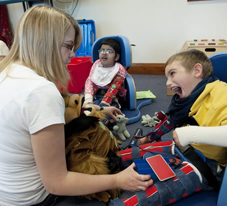 Teacher playing with disabled boy.