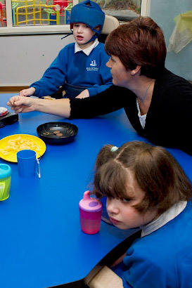 Disabled boy receiveing 'thumbs
up' from carer.