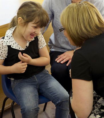 The same female teacher engages
                  with a young female pupil