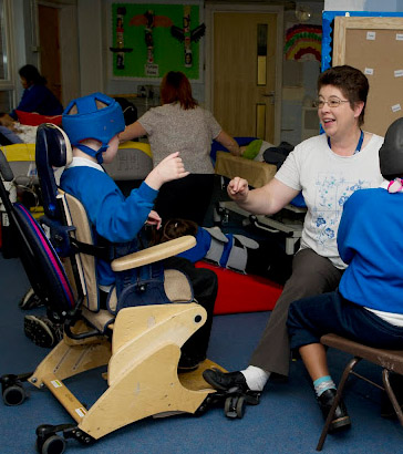 Teacher interacting with a disabled
                  boy