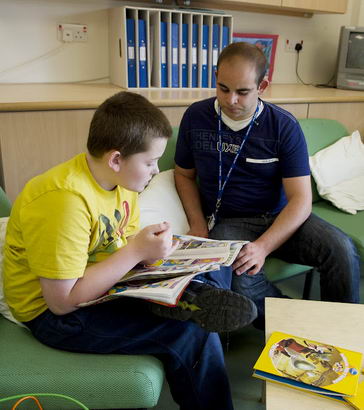 A male teacher and young boy conduct
                  a qualitative research exercise