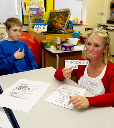 teacher at table talking to small
                  group