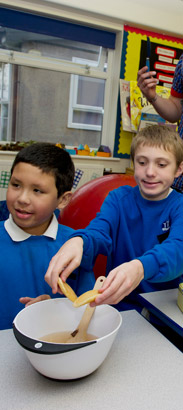 teacher helping group with cooking