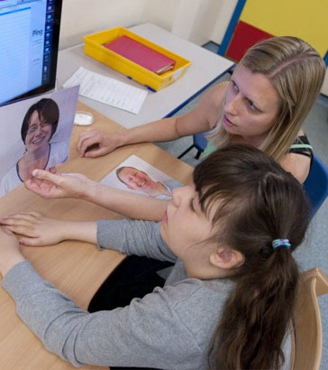 Two teachers sit in front of a computer