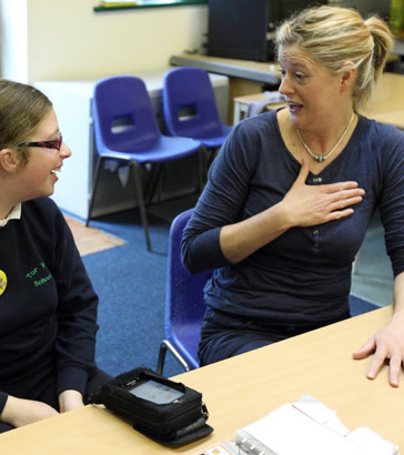 teacher hand on desk, hand on chest 