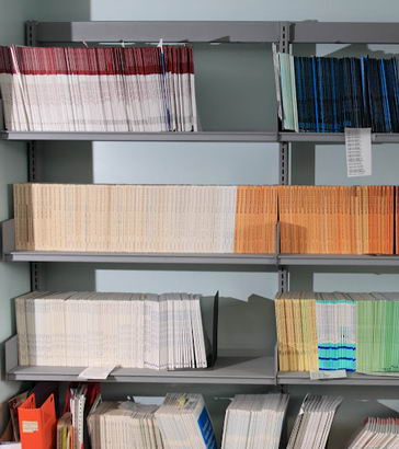 Library shelves containing research reports
                  and journals